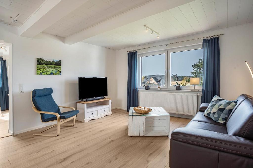a living room with a couch and a television at 5 Sterne Ferienwohnung Boddenblick in Glowe
