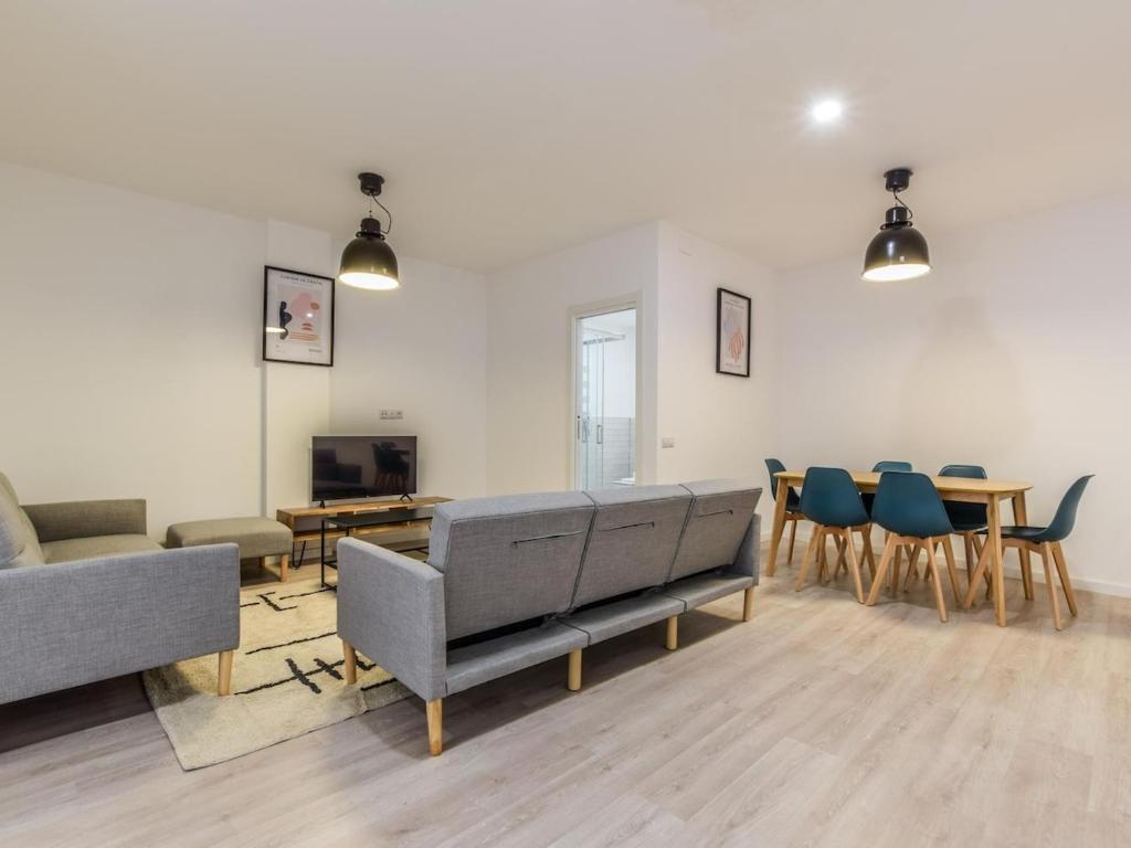 a living room with couches and a table and chairs at apartamentos en madrid rio reformados in Madrid