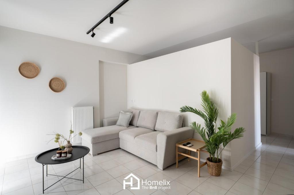 a white living room with a couch and a table at Agora Central Home in Chalkida