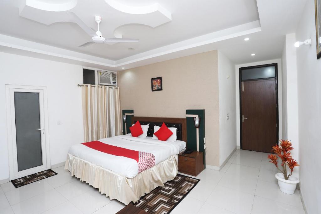 a bedroom with a large bed with red pillows at Super Capital O Levanti Near Aravali Biodiversity Park in Gurgaon