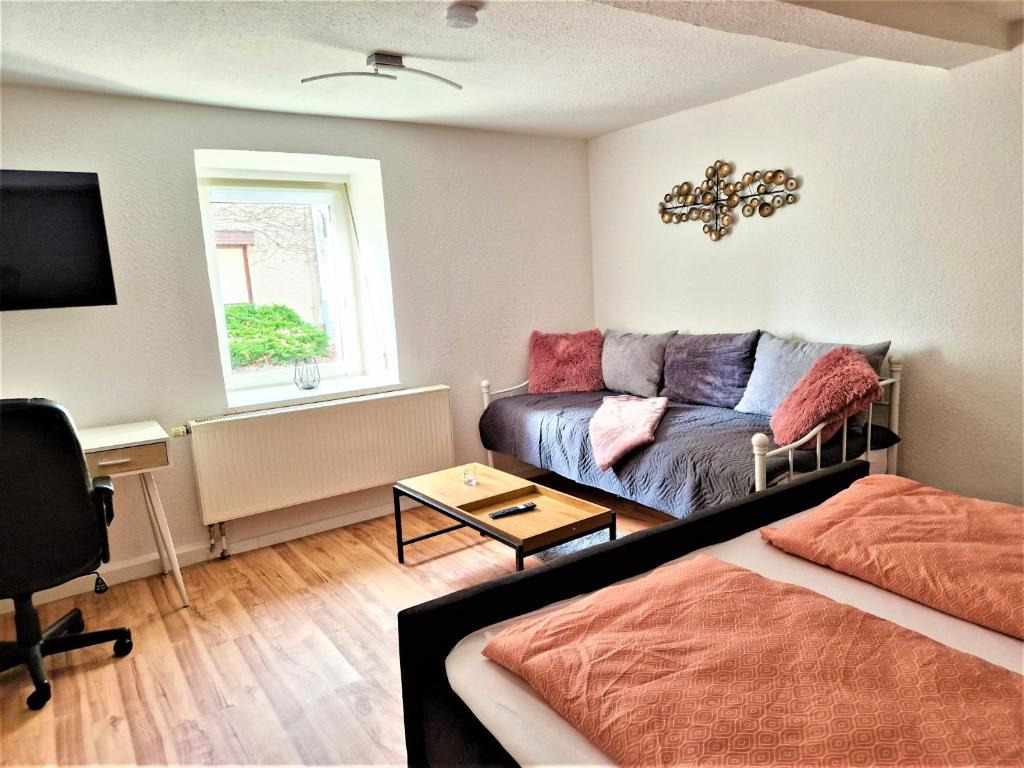 a living room with a bed and a couch at modernes Landhaus Charlie - Nähe Halle, 4 Zimmer in Petersberg