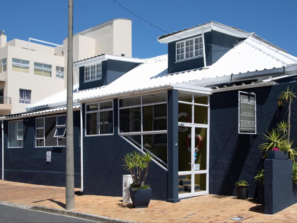 a blue building with a white roof at Loddey`s Guest House in Strand