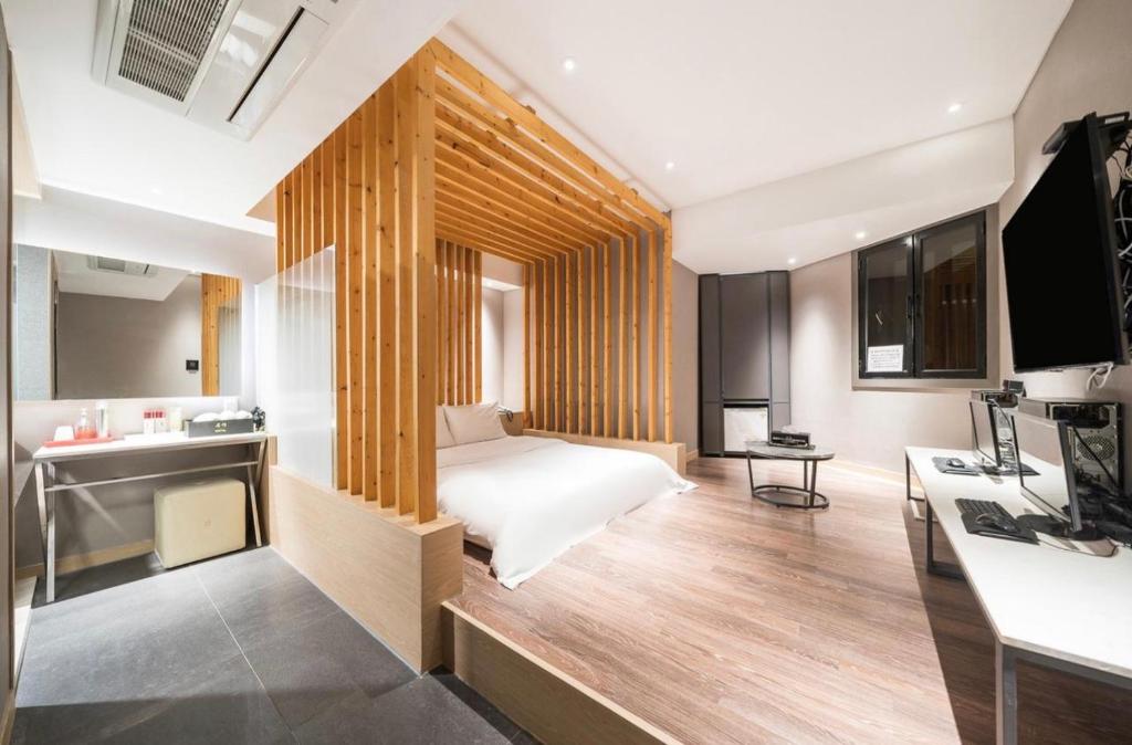 una camera d'albergo con letto e scrivania di HOTEL MYEONG JAK a Suwon