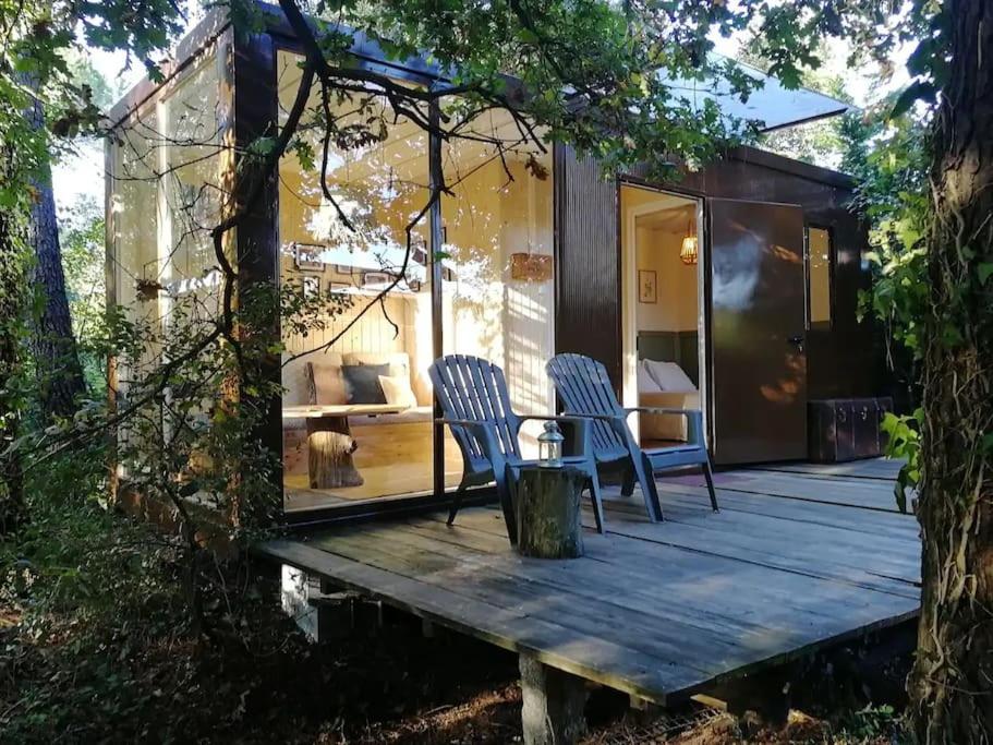 a tiny house with two chairs on a wooden deck at Natura Tiny House Porto in Valongo