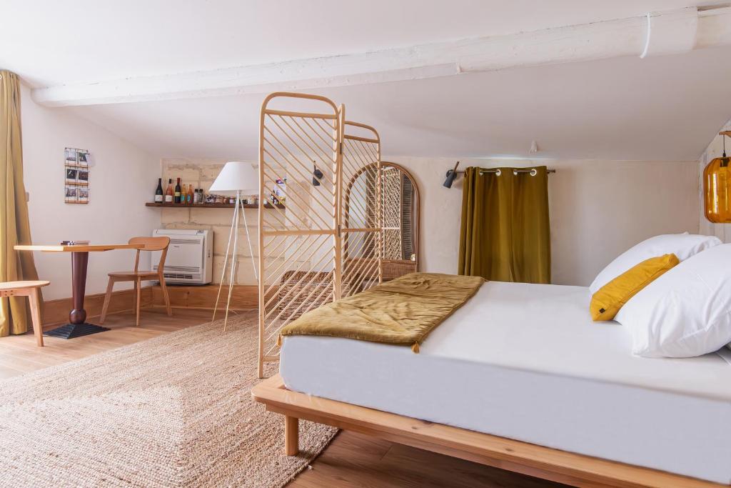 um quarto com uma cama branca com uma estrutura de metal em La Madeleine Arles em Arles