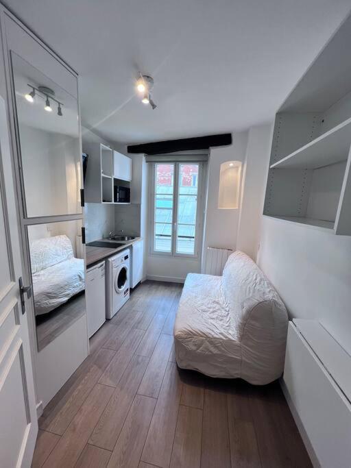 Cette petite chambre comprend un lit et une cuisine. dans l'établissement Paris Montmartre - Studio équipé - 1P, à Paris