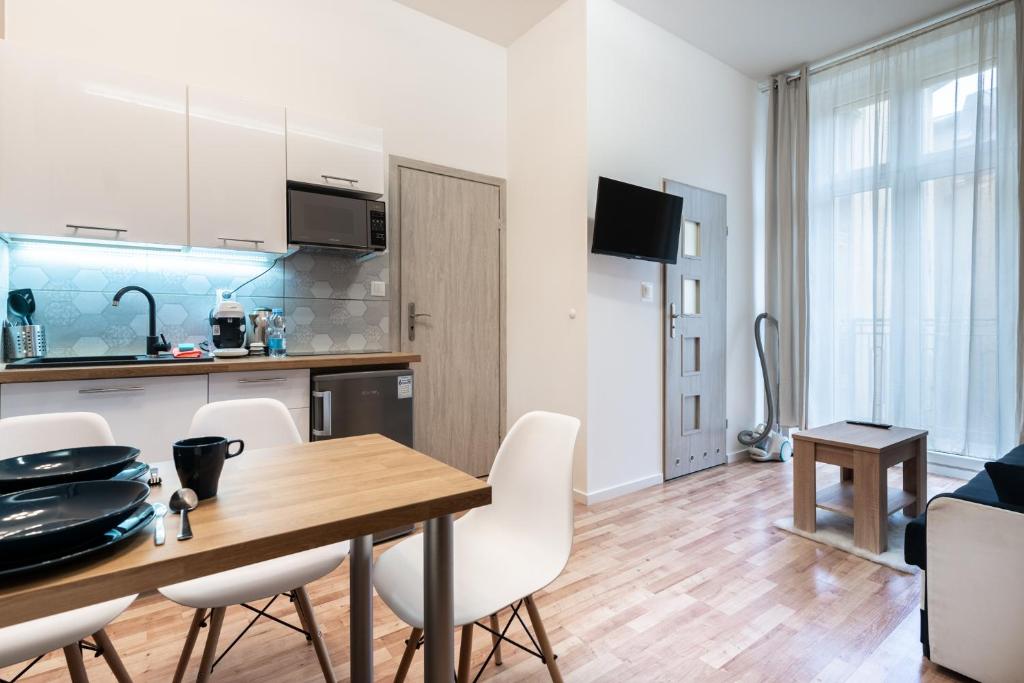 uma cozinha e sala de jantar com mesa e cadeiras em Main Square Teatralna - 2 room apartment with balcony - self-in - coffee and tea em Katowice