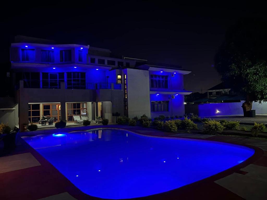 a blue pool in front of a house at night at CASA AZUL ACCOMMODATION in Matola