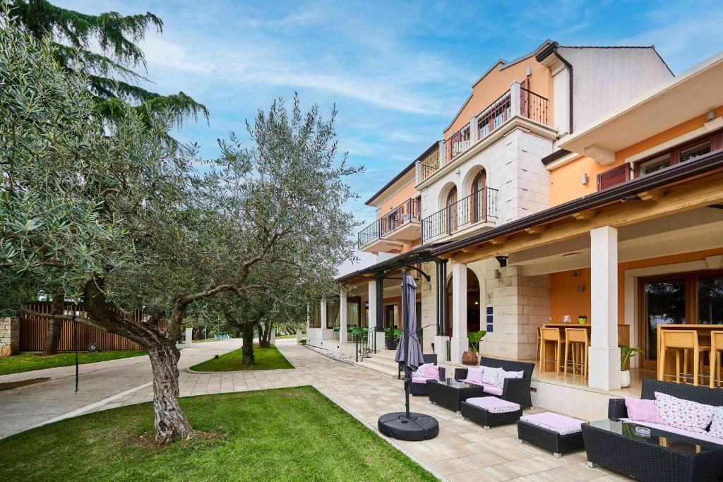 dom z fioletowymi meblami i drzewem na dziedzińcu w obiekcie Villa Dobravac Wine Estate w Rovinj