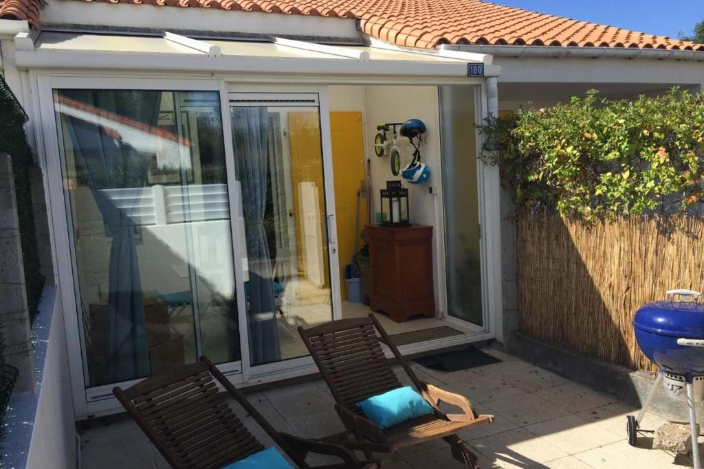 d'une terrasse avec 2 chaises et une porte coulissante en verre. dans l'établissement Maison de vacances plage des demoiselles St Jean, à Saint-Hilaire-de-Riez