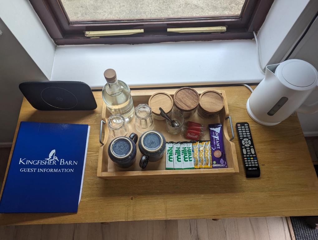 a tray of items on a table next to a book at Kingfisher Barn B&B in Abingdon