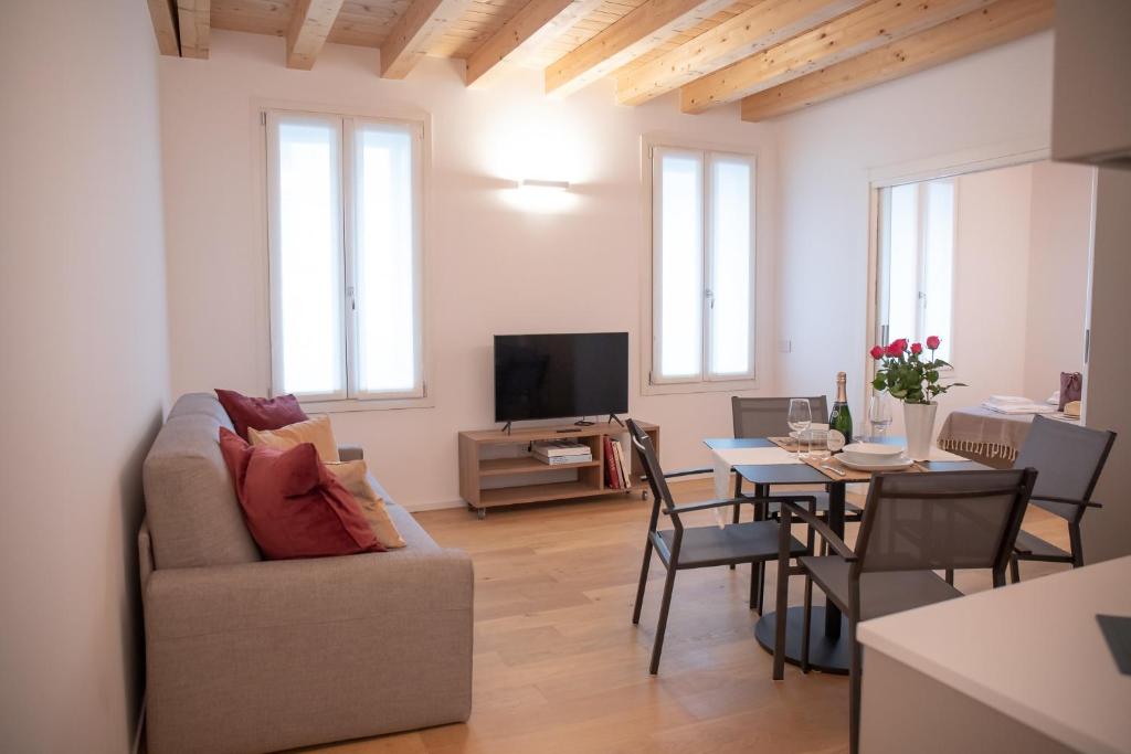 una sala de estar con un sofá y una mesa en Romantic White Apartment - 5 minutes from the lake, en Como