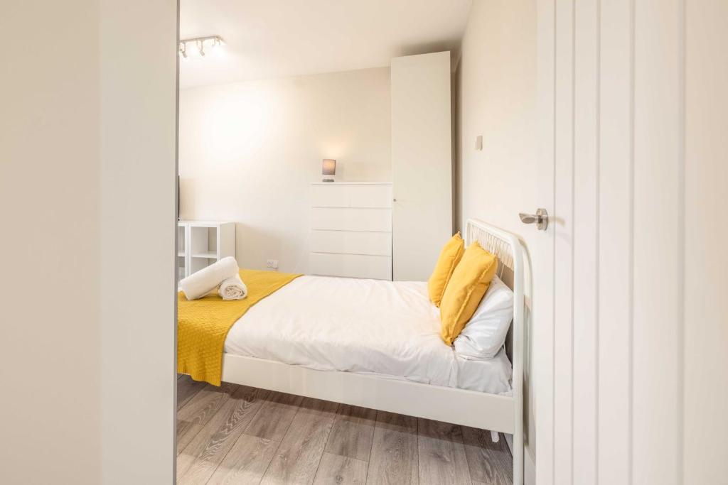 a small bedroom with a bed and a mirror at Cosy Heathrow Apartment - Free Parking in Colnbrook