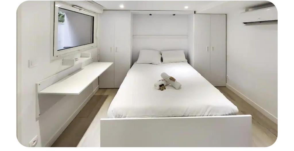 een witte slaapkamer met een teddybeer op een bed bij Les Garennes in Rillieux