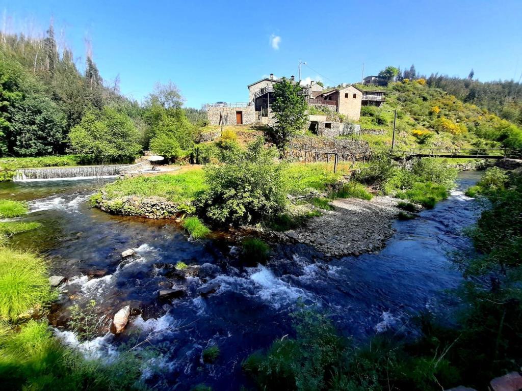 a river with a house in the middle of it at Casa do Moinho Novo I in Fontão Fundeiro