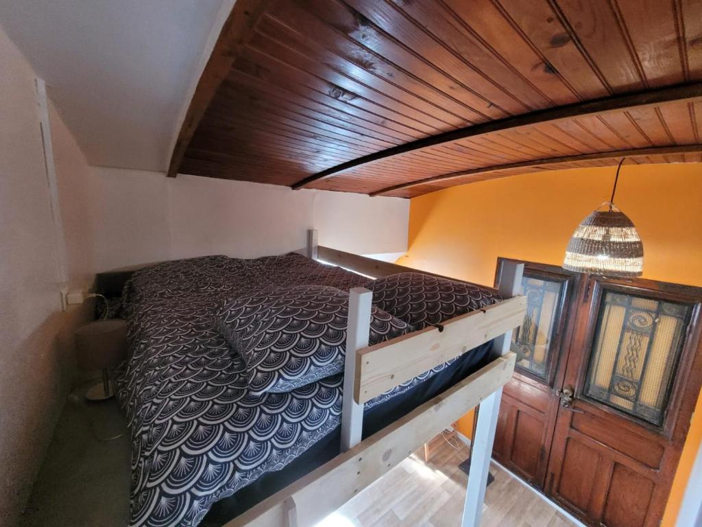 Chambre sur l'eau - Péniche La Diva في كونفلانز سانت أونورين: سرير في غرفة ذات سقف خشبي