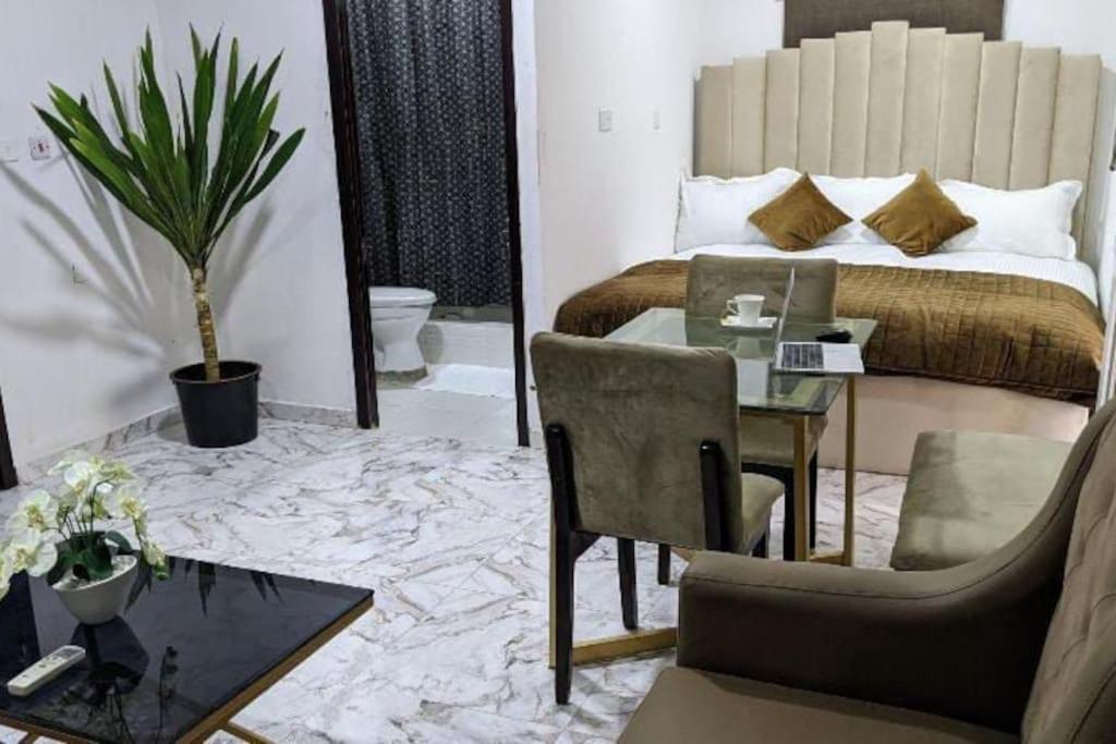 a bedroom with a bed and a table and a chair at Cozy Studio room, Wi-Fi & Smart TV in Lagos