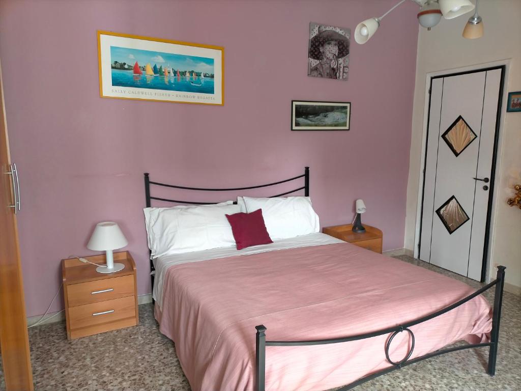 敘拉古的住宿－Sleep In Sicily，一间卧室配有一张粉红色墙壁的床