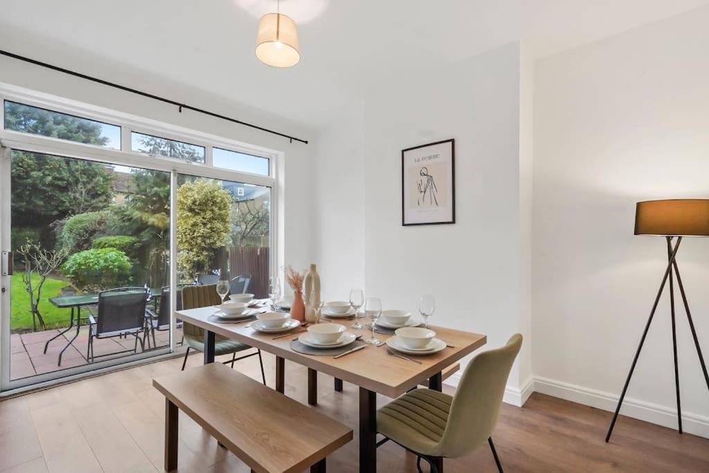 a dining room with a table and chairs and a window at 4 BR House/Free Parking/5mins Walk To Kensal Rise in London