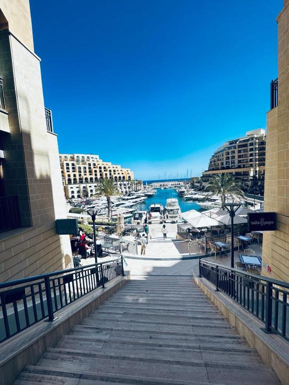 una passerella con vista sull'acqua e sugli edifici di St Julian Luxury Apartment Wish Malta a Paceville