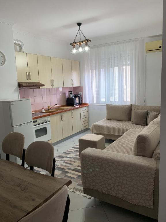een woonkamer met een bank en een keuken bij Ridi's Comfort Apartment 2 in Shkodër
