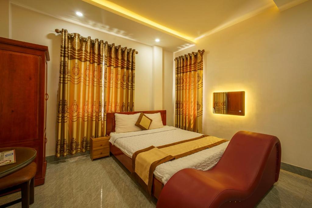 a small bedroom with a bed and a chair at Phú Xuân Hotel in Quy Nhon