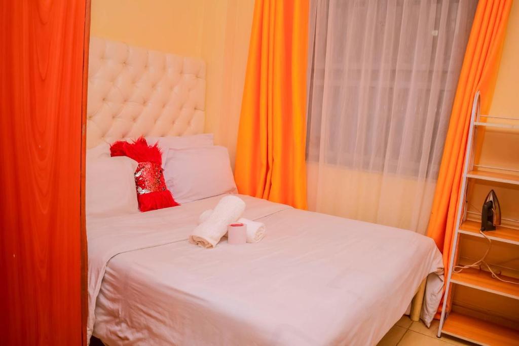 - un lit avec 2 serviettes et 2 tasses dans l'établissement KIsumu Cozy One bedroom Apartment, à Kisumu