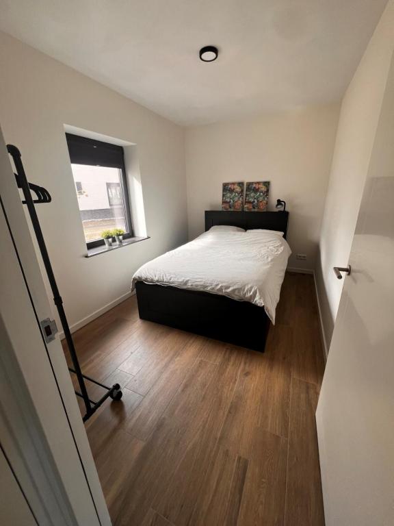 um pequeno quarto com uma cama e uma janela em Luxe recreatiewoning midden in bosrijke omgeving em Waalre