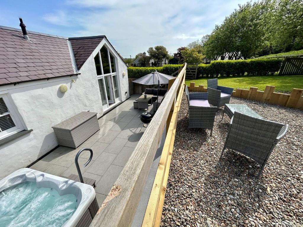 a backyard with a jacuzzi tub and some chairs at 3 Bed in Lamphey 82584 in Lamphey