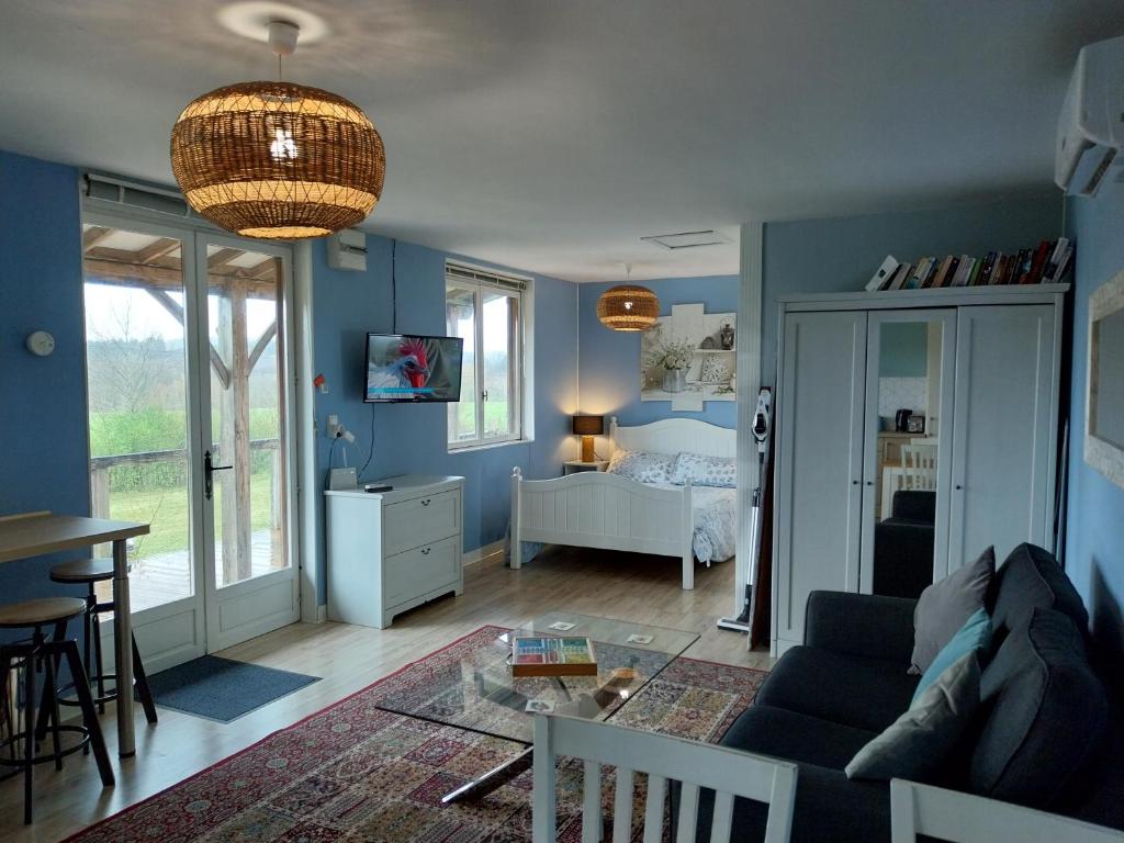 a living room with a couch and a bedroom at La Petite Maison à Vieillecour in Saint-Pierre-de-Frugie