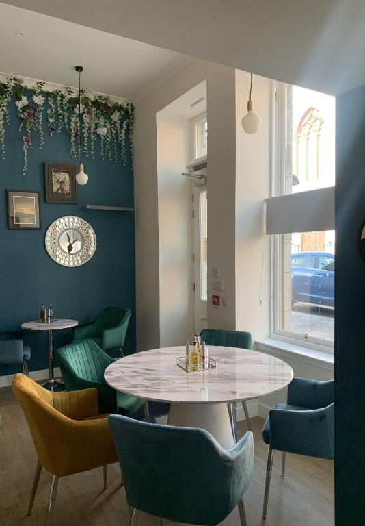 a dining room with tables and chairs and a window at STAG & THISTLE HOTEL AND RESTAURANT in Fraserburgh