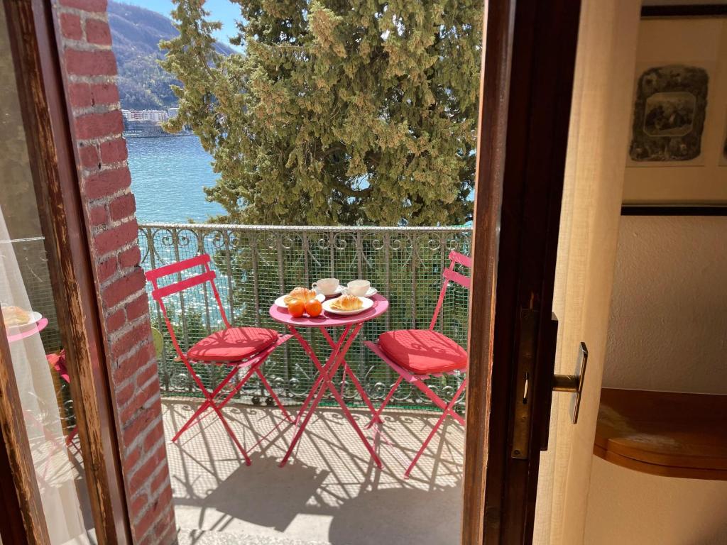 a table with two chairs and a plate of fruit on a balcony at Lake Front View on Viale GENO in Como