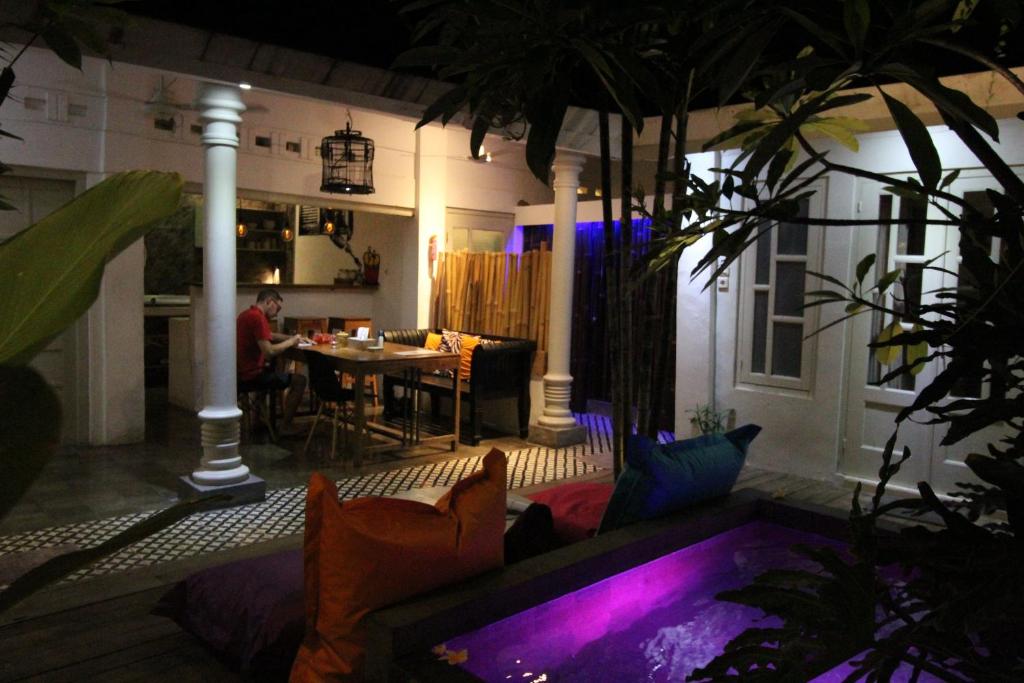 a man sitting at a table in a living room at night at The Patio Yogya in Yogyakarta