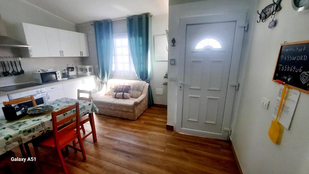 eine Küche und ein Esszimmer mit einem Tisch und einer Tür in der Unterkunft casa las olas in Costa Del Silencio