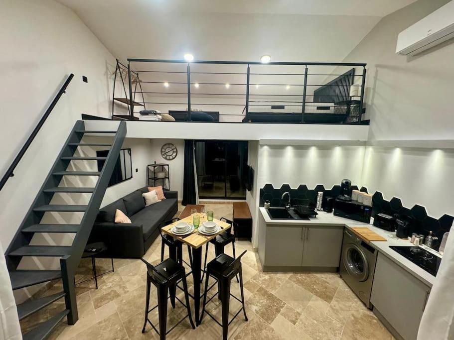 - un salon et une cuisine avec un escalier dans une maison dans l'établissement Saint Remy de Provence: Loft, à Saint-Rémy-de-Provence