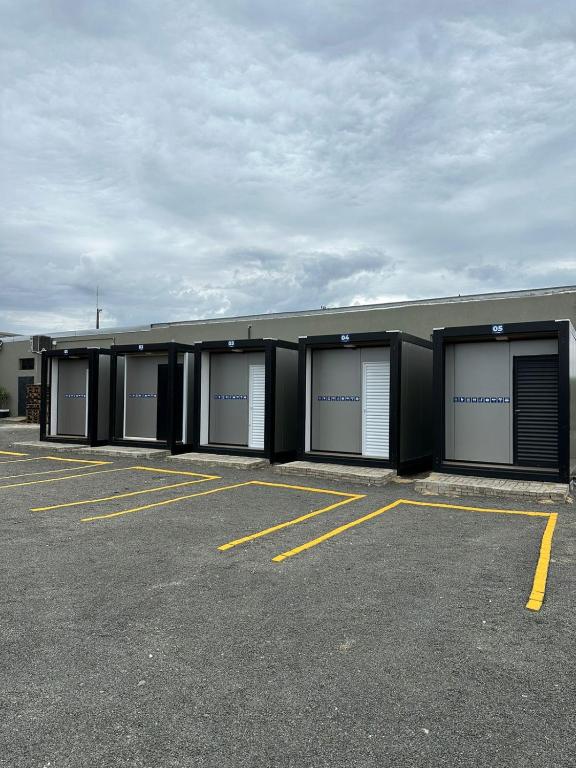 a row of four garage stalls in a parking lot at Hotel In Box in Irati