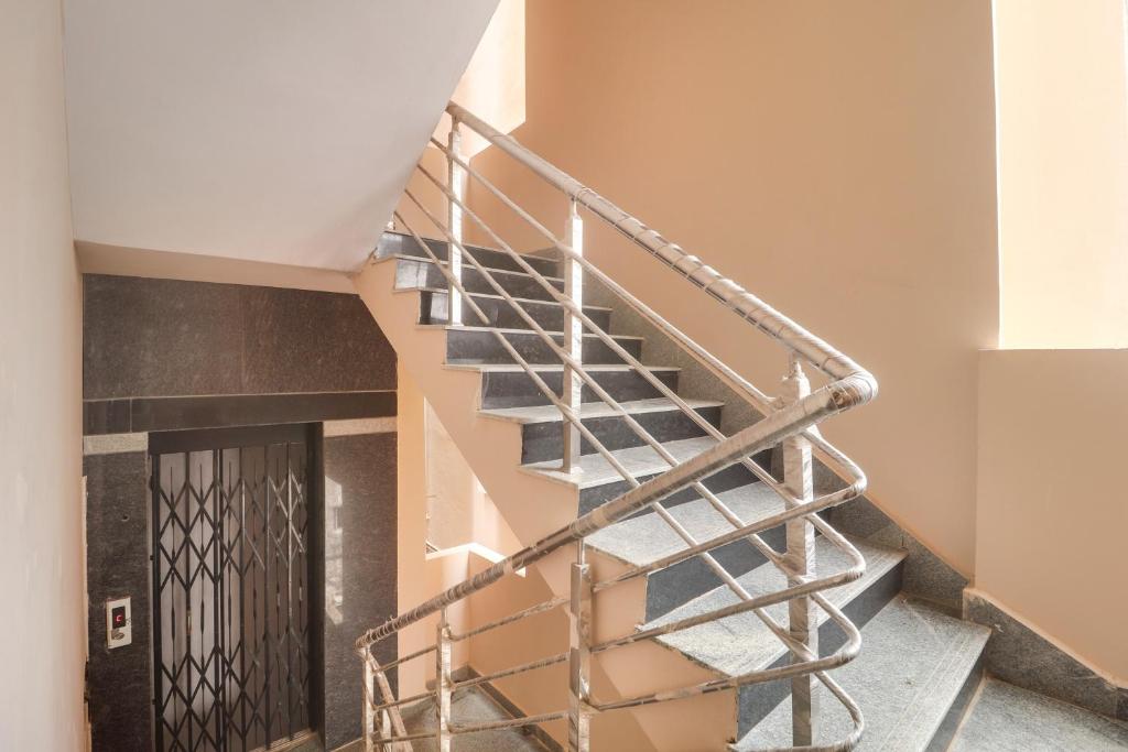 a metal spiral staircase in a building with a door at Super OYO Collection O Hotel Sbr Luxury Rooms in Hyderabad