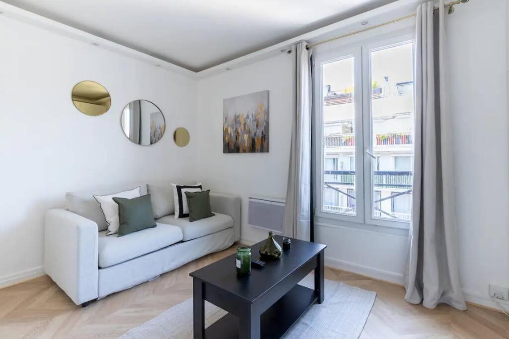 ein Wohnzimmer mit einem weißen Sofa und einem Tisch in der Unterkunft So Ouest/Courcelles : Magnifique Studio in Levallois-Perret