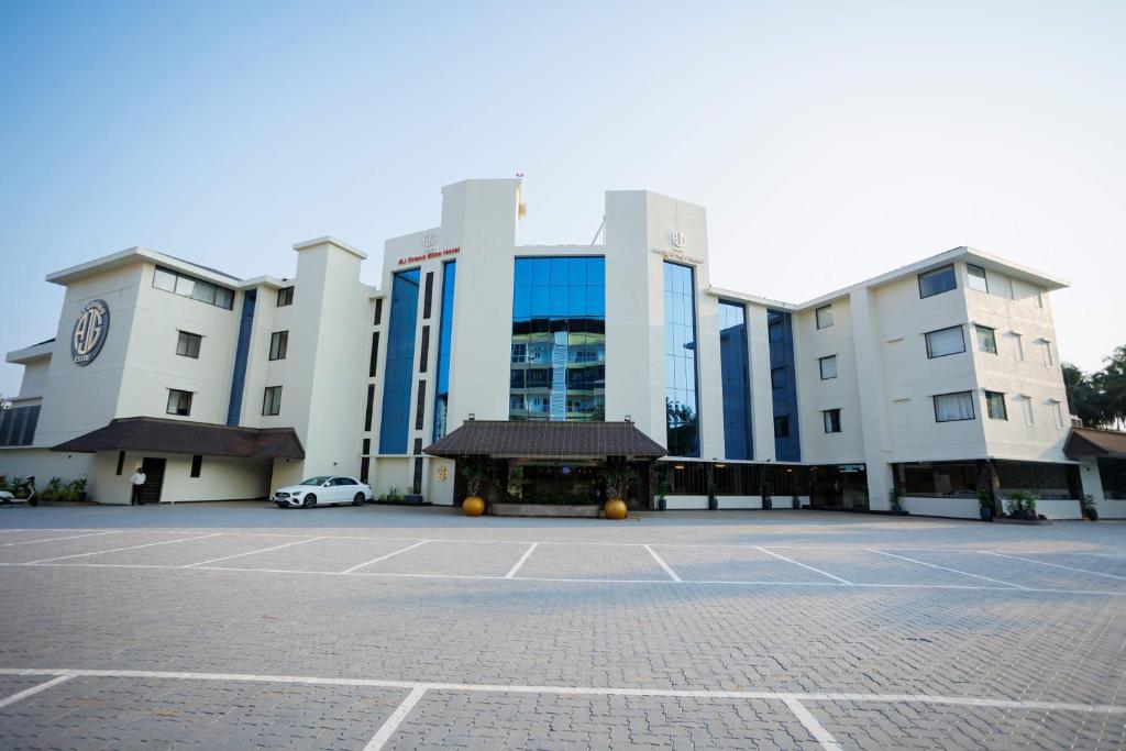 um grande edifício com um parque de estacionamento em frente em AJ GRAND ELITE HOTEL em Mangalore