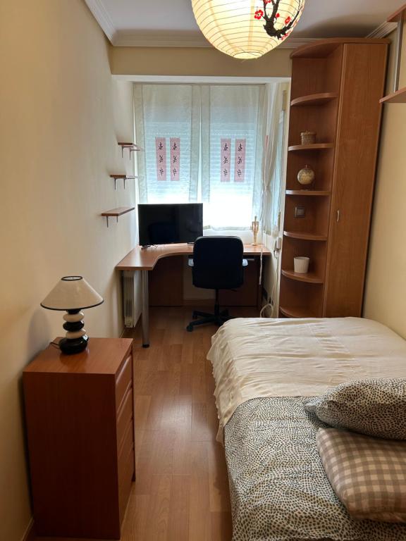 a bedroom with a bed and a desk with a computer at Cómoda Habitación Individual in Madrid