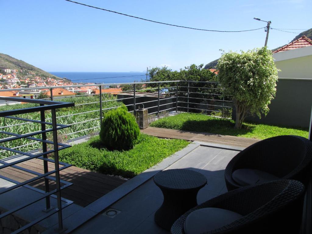 Un balcón con sillas y vistas al océano. en Vivenda Madalena, en Machico