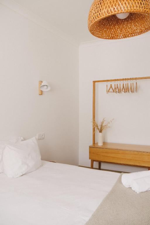 a bedroom with a bed and a chandelier at Pure Flor de Esteva in Vila do Bispo