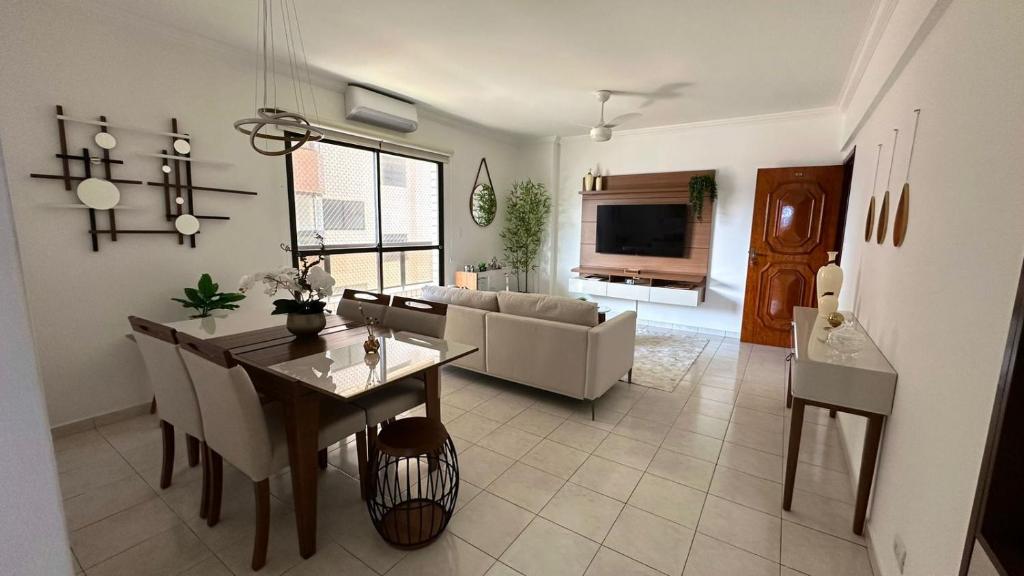 a living room with a couch and a dining room at Apto Lindo e Completo Beira Mar - Vila Caiçara in Solemar