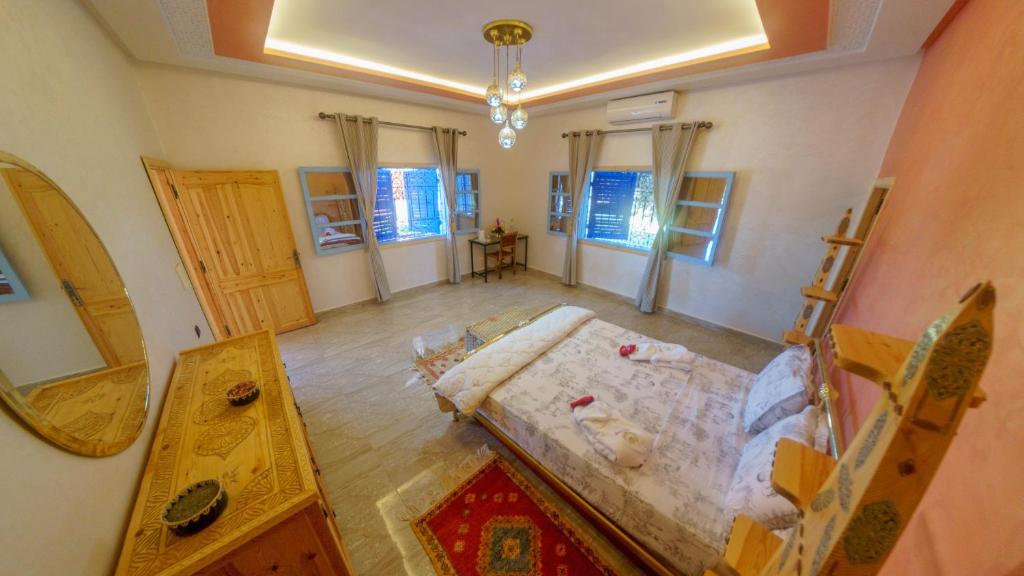 Zimmer mit einem Bett, einem Tisch und Fenstern in der Unterkunft Villa Coup De Cœur in Marrakesch