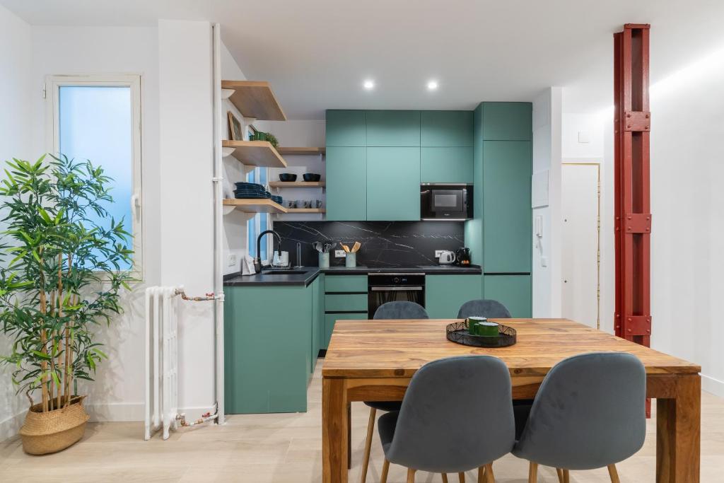 una cocina con armarios verdes y una mesa y sillas de madera. en Executive -2Bedrooms 2Bathrooms - Salamanca - MintyStay, en Madrid