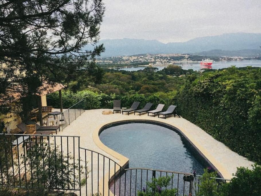 - une piscine avec des chaises et une vue sur l'eau dans l'établissement Grande villa familiale vue mer près de Palombaggia, à Porto-Vecchio