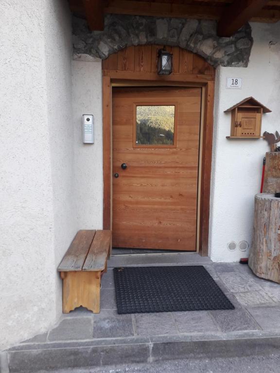 una puerta de madera con un banco delante en Casa De Sandre, en San Vito di Cadore