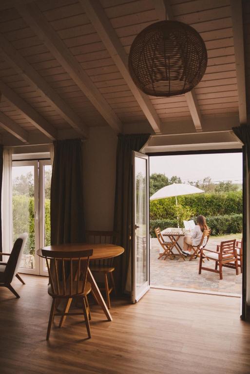 a room with a table and chairs and a patio at Pure Flor de Esteva in Vila do Bispo