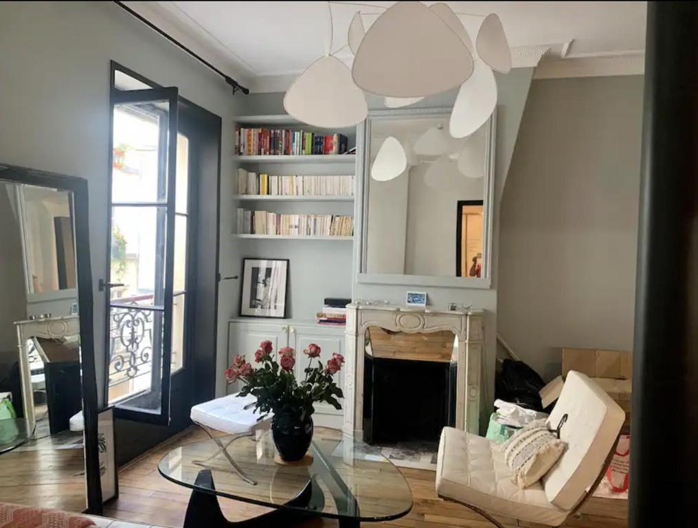 - un salon avec une cheminée et une table en verre dans l'établissement Heart of marais calm and charming NEW, à Paris