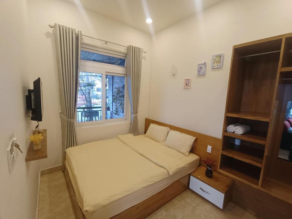 um pequeno quarto com uma cama e uma janela em OYO 1235 Linh's House em Da Lat